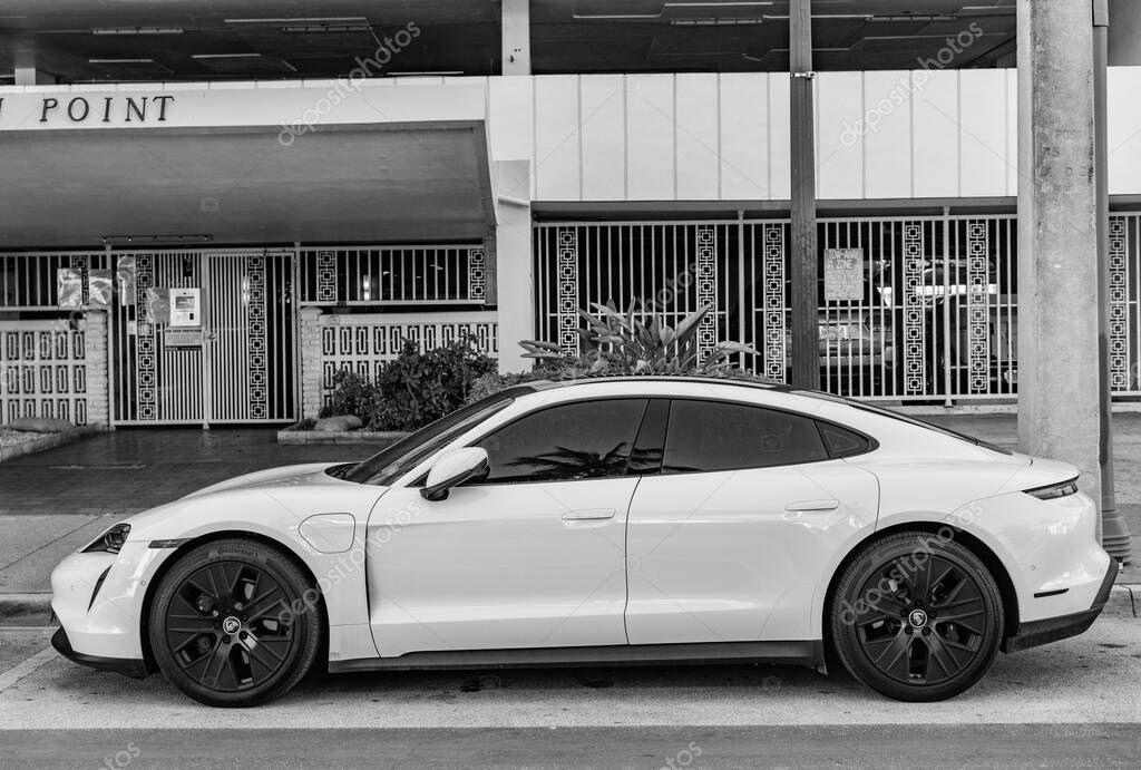 Miami Beach, Florida USA - June 9, 2024: Porsche Taycan white color at miami beach. luxury car porshche at ocean drive Miami beach. front corner view
