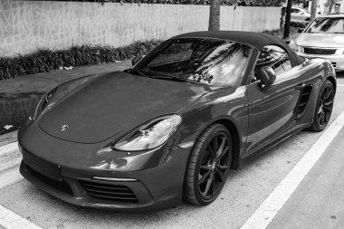 Miami Beach, Florida USA - 9 Haziran 2024: 2018 Porsche 718 Boxter 's orange color at Miami Beach. Ocean 'daki lüks araba porshche' si Miami plajına gidiyor. ön köşe görünümü