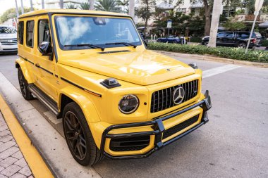 Miami, Florida, ABD - 26 Ocak 2025: Mercedes Benz hibrit araba açık havada park edildi. Sarı araba, köşe manzaralı. 2025 Mercedes Benz G sınıfı hibrit araba. Lüks elektrikli ve motorlu Mercedes Benz G sınıfı..