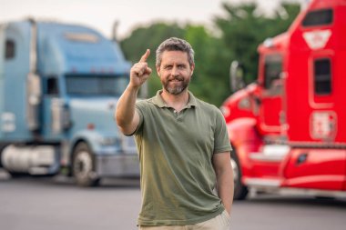 Yarı kamyon aracı. Kamyon şoförü. Ulaşım endüstrisi. Kamyonetin yanında bir adam var. Kamyon şoförü. Kamyon sahibi. Nakliye araçları. İspanyol adam kamyonun önünde işaret ediyor..