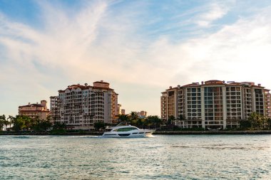 Marinaya yüzen bir tekne. Fisher Adası 'nda lüks bir yat teknesi. Yaz tatili. Fisher Adası konut binası ve lüks yat teknesi. Miami Fisher Adası Panorama Manzarası.