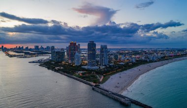 Miami sahil şeridinin hava gece görüşü. Miami Okyanusu 'nun üzerindeki alacakaranlık silueti. Miami Sahili kıyısı gün batımından sonra parlıyordu. Gökten ünlü Miami Sahili
