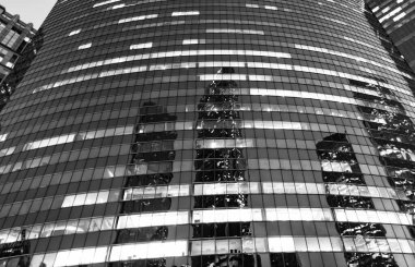 Camdan yapılmış bir gökdelen. Modern cam bina. Şehir merkezindeki gökdelen. Şehir merkezinde gökdelenli. İş bölgesindeki ofis binası. Gökdelen mimarisi. Cam cephe.