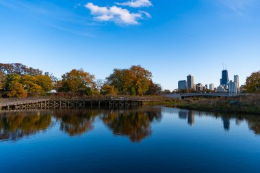 Su yansıtma gölü olan şehir parkı. Sonbahar manzarası. Park göleti. Sonbaharda renkli sonbahar ağaçlarıyla park et. Sonbahar doğası. Sonbahar doğa manzarası. Sonbahar ağacıyla park edilmiş göl.