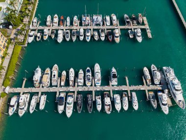 Marinaya yanaşmış lüks yatların havadan görüntüsü. Yatların yukarıdan aşağıya insansız hava aracı görüntüsü. Tekneler ve yelkenliler Manzaralı deniz kıyısında