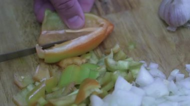  Amatör bir aşçı kesme tahtasında sebze biberi keser..