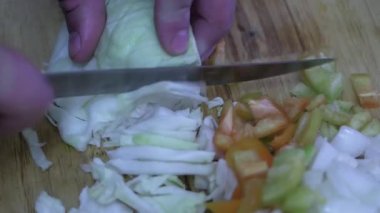 Amatör bir aşçı kesim tahtasıyla lahana keser, yakın plan.