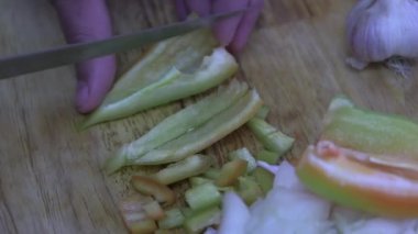  Aşçı yemek pişirmek için sebze biberi kesiyor.