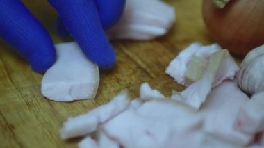  Aşçının eli küçük parçalara ayrılır. Kesme tahtasıyla taze domuz yağı, yakın plan..