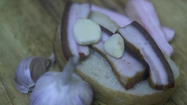 Hand Zet Knoflook Brood Met Gerookte Reuzel Hagelslag Zwarte Gemalen — Stockvideo