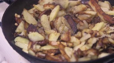  Aşçı karabiber ekliyor ve iştah açıcı ekmeği yakın plan bir tavada karıştırıyor.