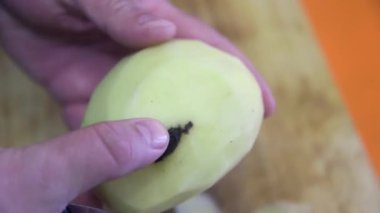 Şef patatesin hasarlı kısmını bıçakla alıyor..