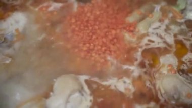 Ucuz tavuk ayağı çorbasına kırmızı mercimek eklemek, yakın plan, üst manzara.