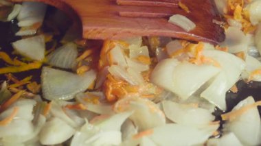 Kızartma tavasında doğranmış soğan ve doğranmış havuç, makro..