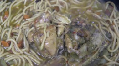  Makarnalı sos ve tavada ısıtılmış tavuk kanadı, yakın plan.