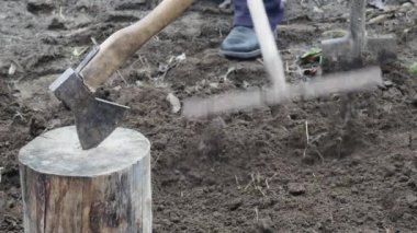 Çiftçi bahçedeki yumuşak siyah toprağı tırmıklıyor