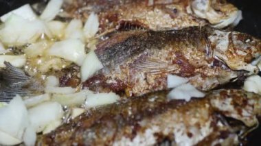  Elinde kaşıkla bir el, tavada doğranmış soğan ve sarımsak karıştırır.