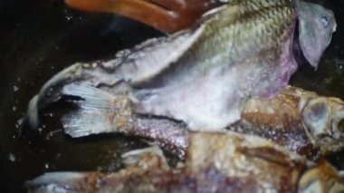 Tahta kaşık tavadaki balığı çeviriyor..