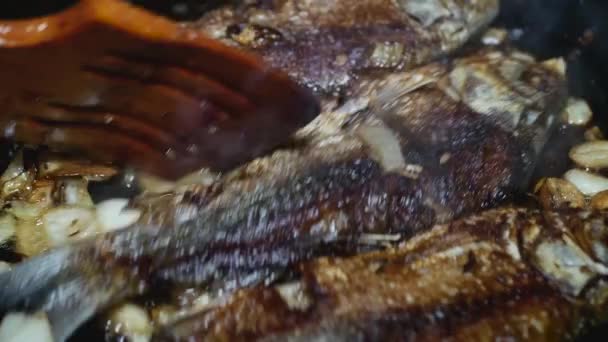 Ein Holzlöffel Bewegt Den Fisch Mit Zwiebeln Einer Pfanne Nahaufnahme — Stockvideo