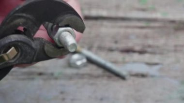 Bir el, ayarlanabilir bir anahtarla somun tutucusundan bir cıvata çıkarır..