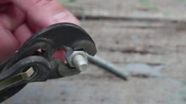 Bir el vidayı somuna çeviriyor ve masanın üzerinde ayarlanabilir bir anahtar tutuyor..