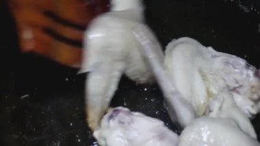  Tahta kaşık, tavada yarı pişmiş kanat çırpar.