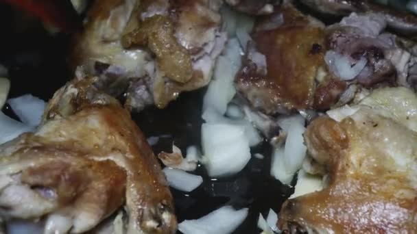Ein Holzlöffel Rührt Einer Pfanne Gebratene Hühnerflügel Mit Gehackten Zwiebeln — Stockvideo