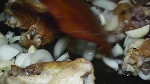 Μια Ξύλινη Κουτάλα Ανακατεύει Τηγανητά Φτερά Κοτόπουλου Ψιλοκομμένα Κρεμμύδια Και — Αρχείο Βίντεο