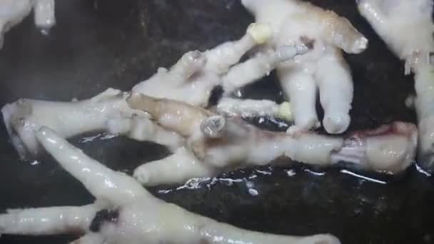 用切好的爪子在锅中的沸腾油中搅拌鸡腿 — 图库视频影像
