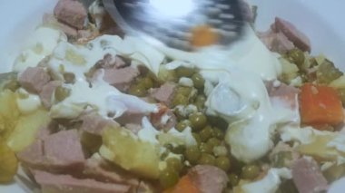 Bir kaşık mayonezi karıştırır ve sıradan Sovyet insanlarından oluşan şenlikli bir salata haline getirir..