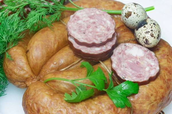 two types of sausages on a white cutting board with a green sprig of dill and parsley, with quail eggs.