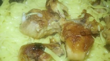  appetizing chicken drumsticks with crust and noodles.