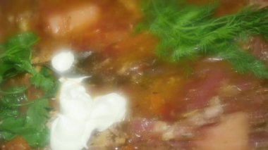 hot red borscht with parsley and mayonnaise, close-up, a popular dish in Ukraine, Moldova and Russia