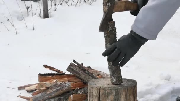 一只戴着手套的手不能在雪地的院子里从木头上拔出斧头 动作缓慢 — 图库视频影像