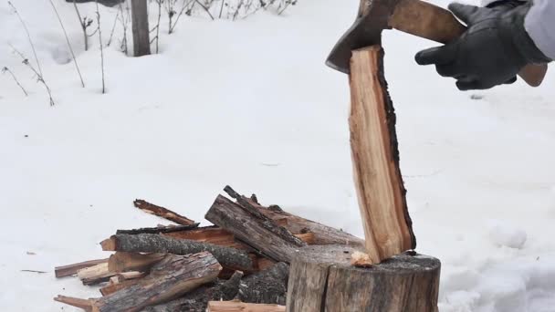 一只手 手戴黑色手套 斧头在雪地覆盖的院子里为炉子切木头 动作缓慢 — 图库视频影像