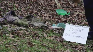Eski plastik şişeler çöplerle dolu bir ormana düşerler, yavaş çekimde, doğanın saflığıyla ilgilenme kavramı..