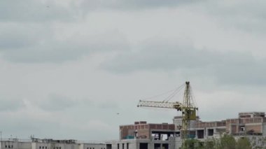 Güzel bulutların hareket hızının bir evin inşaatı üzerine bir kule vincinin üzerinden geçmesi..