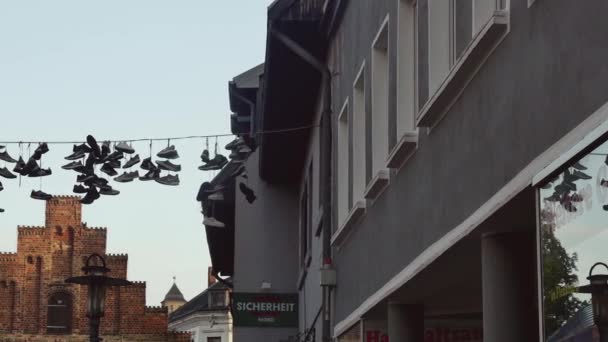 德国弗伦斯堡 2023年8月27日 弗伦斯堡 许多被遗弃的鞋子挂在铁丝上 在历史名城的门前 — 图库视频影像