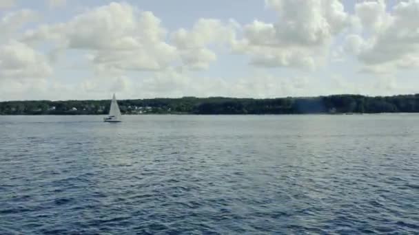 Widok Morza Pływającego Jachtu Żaglowego Brzegu Drzewami Niebo Pięknymi Chmurami — Wideo stockowe