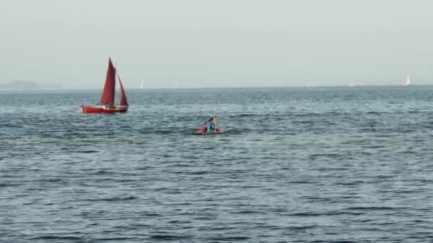 德国弗伦斯堡 2023年9月10日 一名运动员驾驶一艘单人皮划艇 在一艘漂亮的帆船和飞鸟的衬托下在水里倾覆 — 图库视频影像