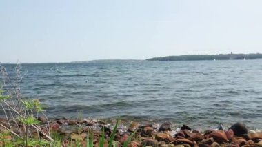 Deniz dalgaları kıyıdaki kayalara vuruyor, deniz manzarası.