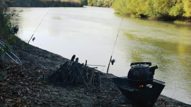 グリルのティーポット 釣り棒と美しい川の背景に対して — ストック動画