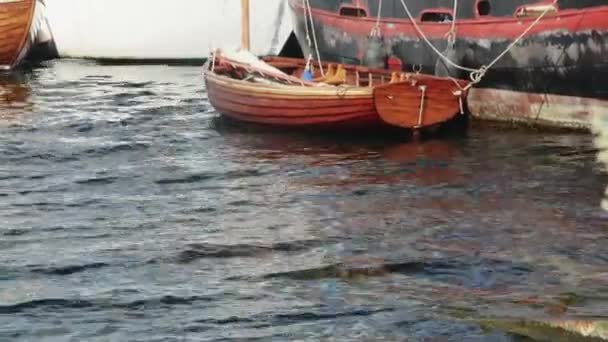 在绑在一艘旧船上的波浪上摆动的木船 — 图库视频影像