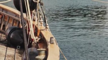 Limanda sakin bir denizde demirli bir yelkenli gemisinin sallanan güvertesi.
