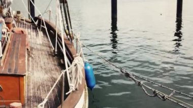 İskeleye demirlemiş bir yelkenlinin sancak tarafının görüntüsü