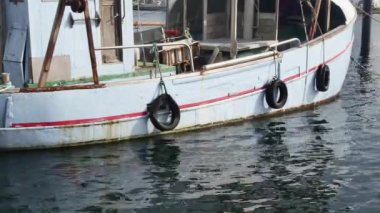 Şehir limanında demirli mavi eski bir geminin tahtası.