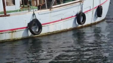 Limandaki eski mavi bir geminin tahtasına.