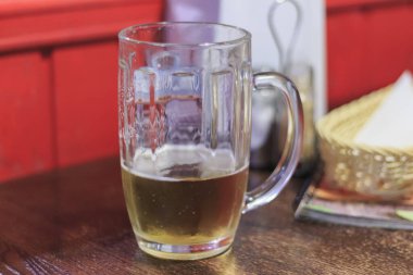 Bardaki bir masada yarım bardak boş bira..