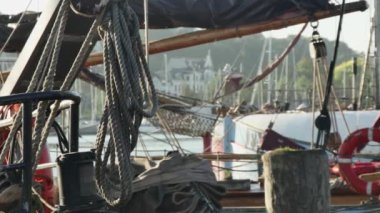 Limanda halatları ve can simidi olan demirli bir yelkenli gemisinin güvertesine.