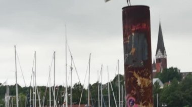 Şehir limanında paslı bir sütunun üzerinde bir martı duruyor..